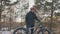 Professional extreme sportsman biker to bear fat bike to up mountain in outdoor. Cyclist walk in winter snow forest. Man