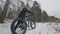 Professional extreme sportsman biker walk with fat bike in outdoors. Cyclist walking in the winter snow forest. Man go