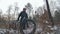 Professional extreme sportsman biker walk with fat bike in outdoors. Cyclist walking in the winter snow forest. Man go