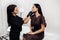Professional female cosmetologist examining face skin of beautiful woman.