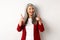 Professional female employer in trendy red blazer and makeup, pointing fingers at camera and smiling, praising something