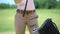 Professional female golf player wearing glove and taking club, ready to game