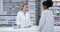 Professional female healthcare pharmacist helping customer at the counter in a pharmacy. Woman health consultant or