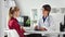 Professional female medic consultation young woman looking at x-ray image surrounded by hospital