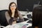 Professional female optician sitting at the table and working