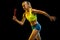 Professional female relay racer training on black studio background in neon light