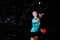 Professional Female Tennis Player Posing with Red Racket and Making Powerful Smash Against Water Droplets On Black