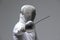 Professional fencer in fencing mask attacking on grey background