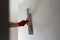 A professional finisher painter levels the walls with putty with a wide spatula