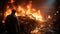 A professional firefighter puts out the flames. A burning house and a man in uniform, view from the back.