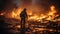 A professional firefighter puts out the flames. A burning house and a man in uniform, view from the back.