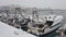 Professional fishing boats stand at the berth covered with snow