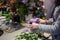 Professional florist hands making a tender lilac bouquet of flowers n the table