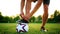 Professional football player at practice tying laces in the boots. Close-up with the ball.