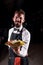 Professional garcon holds salad on a black background.