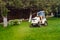 Professional gardener driving a riding lawn mower in a garden