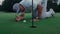 Professional golf player inspect golfing ball hole on green grass course field.