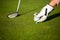 Professional golf player setting up the golf ball on a stand on grass during golf match