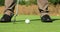 Professional golf player. Unrecognizable man playing golf, hitting ball in distance with golf club at summer day