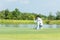 Professional Golfer asian man playing aiming shot for putting ball on the hole with club on green course.  Hobby in holiday and va