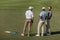 Professional golfers talking while standing on green pitch