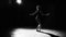 Professional graceful flexible ballerina dancing on her pointe ballet shoes in spotlight on black background in studio