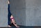Professional gymnast doing warming-up stretching exercise performing standing split against wall in studio