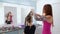 Professional hairdresser doing hairstyle for young pretty woman with long hair