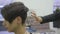 Professional hairdresser shows the back view of the haircut using mirror to handsome satisfied female client in a