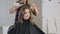 Professional hairdresser stylist curling up teen girl hair