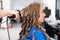 Professional hairdresser using curling iron for hair curls