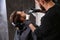 Professional hairdresser using talcum powder to calm client`s skin after shaving