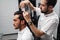 Professional hairstylist is cutting the client\'s hair