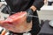 Professional ham slicer cutting an Iberian ham with a long knife