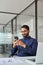 Professional Indian business man working using smartphone in office. Vertical