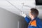 Professional installation of hidden wiring and electrical appliances, installs a motion sensor in the suspended ceiling plate