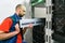 A professional installs a new battery pack into an uninterruptible power supply. Replacing the power module in the server room