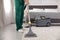 Professional janitor removing dirt from carpet with vacuum cleaner in bedroom. Space for text