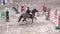 Professional jockey and his horse jump over the barrier.