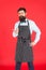 Professional in kitchen. Man with beard cook hipster apron. Hipster chef cook red background. Bearded man chef cooking