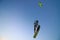 Professional kite boarding rider sportsman with kite in sky jumps high acrobatics kiteboarding trick with grab of kiteboard and
