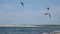 Professional Kite Surfers in action on Waves in sea.  Kites flying in air scenic background.