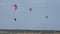Professional Kite Surfers in action on Waves in sea.  Kites flying in air scenic background.