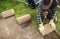 Professional Landscaper Rolling Out Natural Grass Turfs Inside a Garden