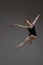 Professional leaping ballerina dancing against gray background