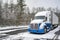 Professional long haul big rig semi truck with reefer semi trailer standing for rest on the winter truck stop parking lot with
