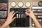 Professional makeup artist taking brush from organizer at wooden table