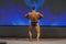 Professional Male Caucasian Bodybuilder Performing on Stage. Back View