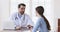 Professional male doctor consult young woman patient at medical visit