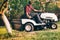 Professional male gardner using lawn mower for cutting grass in home garden